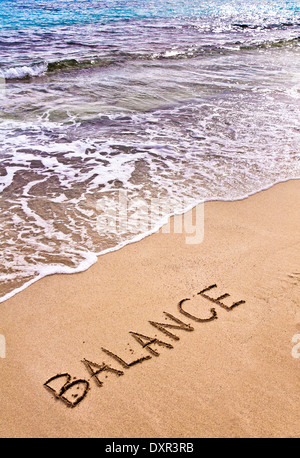Wort zu balancieren, geschrieben auf Sand, mit Wellen des Meeres im Hintergrund, Frieden-Konzept Stockfoto