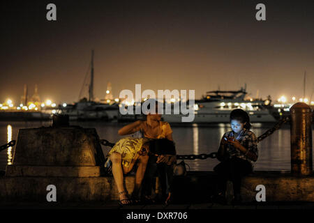 Manila, Philippinen. 29. März 2014. Filipinos Ruhe an einem Dock während der Earth Hour in der Bucht von Manila, Philippinen, 29. März 2014. Die Earth Hour Blue, ein Projekt ins Leben gerufen von der World Wide Fund for Nature (WWF), zielt darauf ab, die Teilnehmer finanziell zu Gemeinschaften auf der ganzen Welt durch Umweltkampagnen unterstützen begeistern. Ein Teil des Erlöses des Projekts wird in Motorboote für die Familien in Küstenorten in den Philippinen eingebaut werden, die von Super Taifun Haiyan im November letzten Jahres betroffen waren. : Bildnachweis Ezra Acayan/NurPhoto: Ezra Acayan/NurPhoto/ZUMAPRESS.com/Alamy Live-Nachrichten Stockfoto