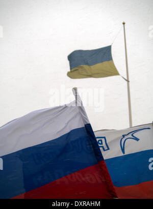 LUGANSK, UKRAINE - 29. März 2014: Ukrainische Flagge über russische Fahnen. Pro-russischen Mitarbeiter inszeniert eine Kundgebung unter dem Vorwand der Proteste in der Ukrainee, auf deren Plakaten lesen "Referendum" und "Janukowitsch - unser Präsident" Credit: Igor Golovnov/Alamy Live News Stockfoto