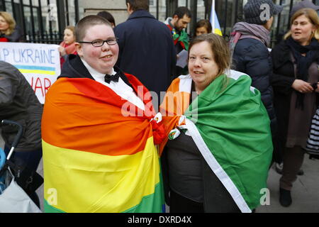 Dublin, Irland. 29. März 2014. Demonstranten sind umhüllt von einer LGBT-Regenbogenfahne und eine irische Flagge. Ukrainer und Iren sowie Anhänger aus anderen Ländern versammelten Dail (Irisches Parlament) in Unterstützung mit den Menschen und Demokratie in der Ukraine und gegen die Besetzung der autonomen Republik der Krim durch Russland. Bildnachweis: Michael Debets/Alamy Live-Nachrichten Stockfoto