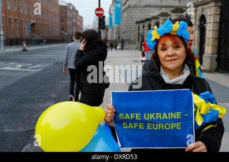 Dublin, Irland. 29. März 2014. Ein Demonstrant trägt einen Kranz in den ukrainischen Farben und ein Zeichen, das "Sichere Ukraine - sicheres Europa" liest. Ukrainer und Iren sowie Anhänger aus anderen Ländern versammelten Dail (Irisches Parlament) in Unterstützung mit den Menschen und Demokratie in der Ukraine und gegen die Besetzung der autonomen Republik der Krim durch Russland. Bildnachweis: Michael Debets/Alamy Live-Nachrichten Stockfoto