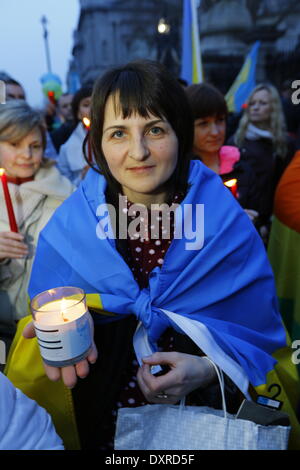 Dublin, Irland. 29. März 2014. Ein Demonstrant ist verpackt in einer ukrainischen Flagge und hält eine Kerze. Ukrainer und Iren sowie Anhänger aus anderen Ländern versammelten Dail (Irisches Parlament) in Unterstützung mit den Menschen und Demokratie in der Ukraine und gegen die Besetzung der autonomen Republik der Krim durch Russland. Bildnachweis: Michael Debets/Alamy Live-Nachrichten Stockfoto