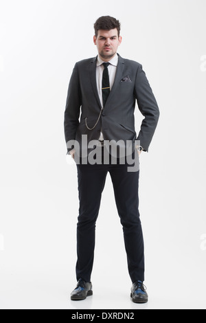 Gut aussehend Geschäftsmann steht in voller Höhe mit gekreuzten Beinen.  Ganzkörper-Schuss von eleganter junger Mann im Anzug, isoliert. Stockfoto