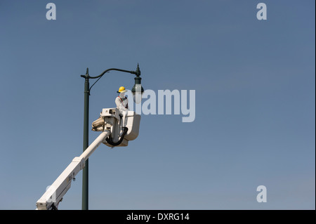 Mann in Aerial Eimer LKW auswechseln Glühbirne in Leesburg, Florida USA Stockfoto