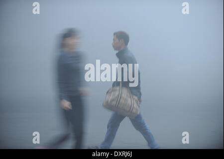 Hefei, China Anhui Provinz. 30. März 2014. Fußgänger Fuß auf einer Straße Nebel eingehüllt in Hefei, Hauptstadt der ostchinesischen Provinz Anhui, 30. März 2014. Bildnachweis: Yang Xiaoyuan/Xinhua/Alamy Live-Nachrichten Stockfoto