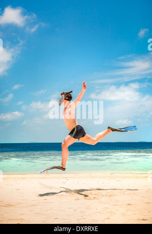 Lustiger Mann springt in Flossen und Maske. Urlaub an einem tropischen Strand auf den Malediven Inseln. Stockfoto