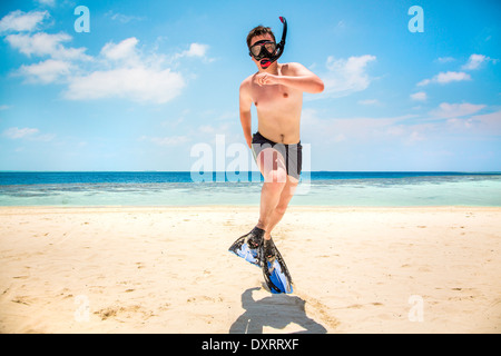 Lustiger Mann springt in Flossen und Maske. Urlaub an einem tropischen Strand auf den Malediven Inseln. Stockfoto