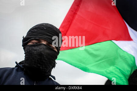 Gaza, Palästinensische Gebiete. 30. März 2014. Ein Demonstrant "Wellenlinien" eine palästinensische Fahne in Richtung der israelischen Grenze während einer Protestaktion anlässlich Tag des Bodens an der Grenze zwischen Israel und Gaza-Streifen am 30. März 2014. 30 März markiert Tag des Bodens, die jährliche Gedenkfeier der Proteste im Jahr 1976 gegen Israels Aneignung von arabischen besaß Land in Galiläa. Bildnachweis: Momen Faiz/NurPhoto/ZUMAPRESS.com/Alamy Live-Nachrichten Stockfoto