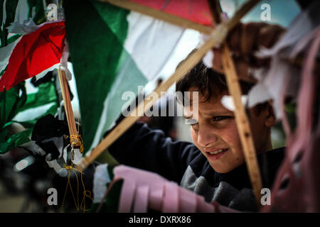 Gaza, Palästinensische Gebiete. 30. März 2014. Ein Demonstrant "Wellenlinien" eine palästinensische Fahne in Richtung der israelischen Grenze während einer Protestaktion anlässlich Tag des Bodens an der Grenze zwischen Israel und Gaza-Streifen am 30. März 2014. 30 März markiert Tag des Bodens, die jährliche Gedenkfeier der Proteste im Jahr 1976 gegen Israels Aneignung von arabischen besaß Land in Galiläa. Bildnachweis: Momen Faiz/NurPhoto/ZUMAPRESS.com/Alamy Live-Nachrichten Stockfoto