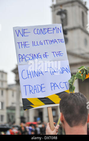 Trafalgar Square, London, UK. 30. März 2014. Taiwanesische Demonstrant hält ein Banner und Sonnenblumen zu einem Protest in Trafalgar Square gegen den China-Taiwan-Handel-Pakt, aus Angst es kann Demokratie auswirken. Bildnachweis: Matthew Chattle/Alamy Live-Nachrichten Stockfoto