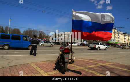 LUGANSK, UKRAINE - 30. März 2014: Fahrrad mit einer festen, eine russische Flagge auf dem Hintergrund der Rallye.  Lugansk separatistischen Rallye versammelt nur etwa 500 Menschen. Alle von ihnen unterstützt die Aufrufe an Russland und nicht die Macht im Kiev.People zu erkennen, die sich als Kämpfer gegen den Faschismus Beifall Anti-Semit Rede Mann zu erklären, die sich als Bergmann aus Krasnyy Luch vorstellte Stockfoto