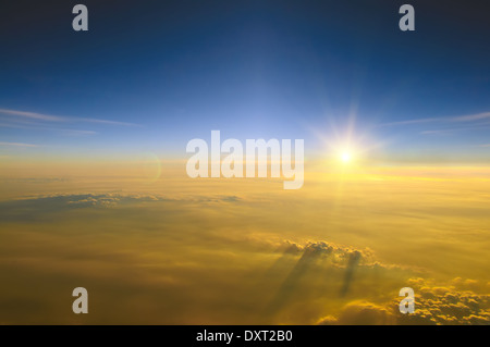 Spektakuläre Aussicht auf den Sonnenuntergang über den Wolken aus Flugzeugfenster Stockfoto