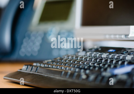 Computer-Tastatur auf einem Schreibtisch mit Telefon und monitor Stockfoto