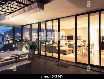 Beleuchtete moderne Wohnzimmer und Terrasse Stockfoto