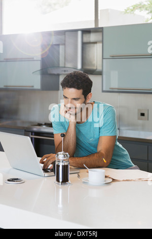 Menschen trinken Kaffee und mit Laptop in Küche Stockfoto