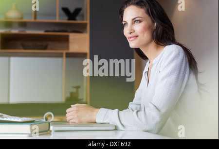 Selbstbewusste Frau, die am Tisch sitzen Stockfoto