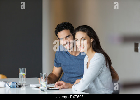 Porträt des Lächelns paar bezahlen Ihrer Rechnungen am Tisch Stockfoto