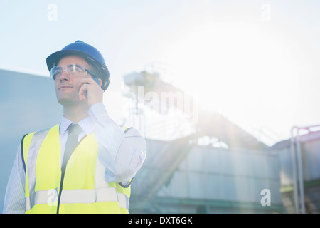 Arbeiter reden über Handy am Getreidespeicher Stockfoto