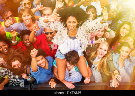 Jubelnde Frau auf ManÍs Schultern beim Musikfestival Stockfoto