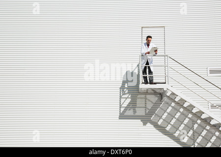 Wissenschaftler stehen auf sonnigen Plattform gegen Gebäude Stockfoto