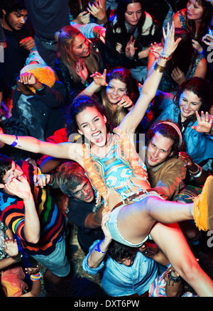 Begeisterte Frau Crowdsurfing beim Musikfestival Stockfoto
