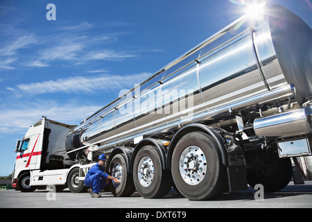 Arbeiter, die Überprüfung der Reifen auf Edelstahl Milch tanker Stockfoto