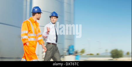 Unternehmer und Arbeitnehmer, die in der Nähe von Silage Speichertürme sprechen Stockfoto