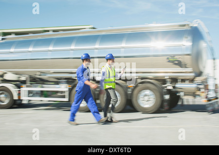 Unternehmer und Arbeiter zu Fuß entlang Edelstahl Milch tanker Stockfoto