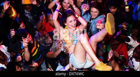 Begeisterte Frau Crowdsurfing beim Musikfestival Stockfoto
