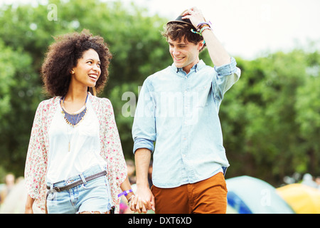 Paar Hand in Hand draußen Zelte beim Musikfestival Stockfoto