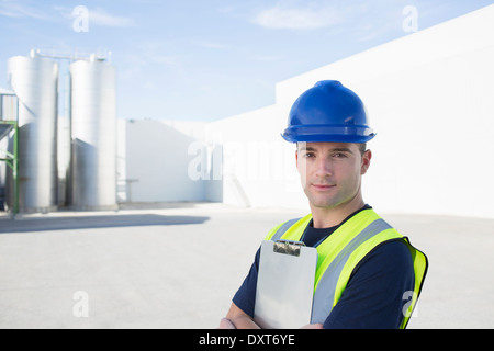 Porträt von zuversichtlich Arbeiter mit Zwischenablage am Getreidespeicher Stockfoto