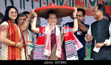 Lakhimpur, Indiens nordöstlichen Bundesstaat Assam. 30. März 2014. Indien der regierenden Kongresspartei Chef Sonia Gandhi (C) erhält eine Japi, eine traditionelle Kopfbedeckung von Kongress-Kandidat Rani Narah (1. L) während einer Wahlveranstaltung in Lakhimpur, Indiens nordöstlichen Bundesstaat Assam, 30. März 2014. Vom 7. April bis Mai 12 halten Indien seine Parlamentswahlen 2014 in neun Phasen. © Stringer/Xinhua/Alamy Live-Nachrichten Stockfoto