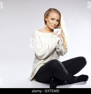 Junge Frau am Boden mit Kaffee oder Tee. Isolierte Schuss mit kopieren Speicherplatz. Stockfoto