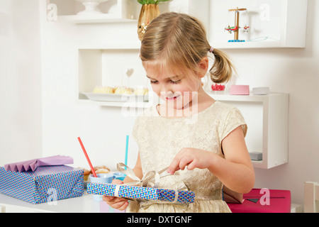 Mädchen auf Geburtstagsgeschenk Auspacken, München, Bayern, Deutschland Stockfoto