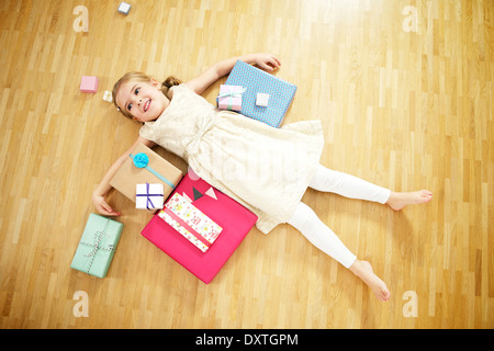 Mädchen auf Rücken unter Geschenk-Boxen, München, Bayern, Deutschland Stockfoto