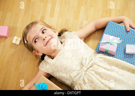 Mädchen auf Rücken unter Geschenk-Boxen, München, Bayern, Deutschland Stockfoto