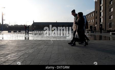 Schüler zu Fuß vorbei an Brunnen außerhalb UAL Central St Martins Kunsthochschule in Granary Square, Kings Cross London N1 KATHY DEWITT Stockfoto