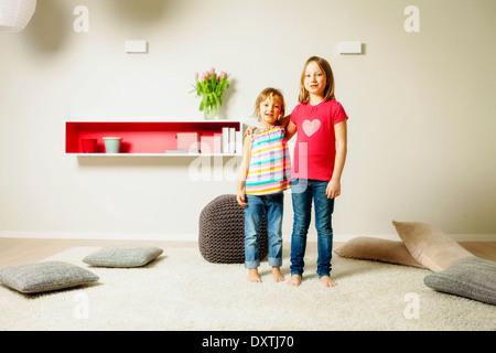 Zwei Mädchen im Wohnzimmer, nebeneinander, München, Bayern, Deutschland Stockfoto