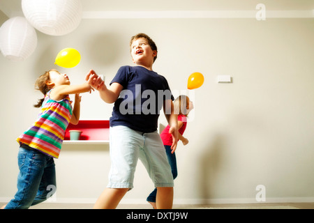 Kinder im Wohnzimmer spielen mit Luftballons, München, Bayern, Deutschland Stockfoto