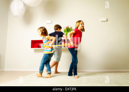 Kinder im Wohnzimmer mit Hula hoop zusammen, München, Bayern, Deutschland Stockfoto