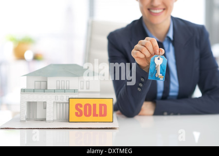 Closeup auf glücklich Makler Frau zeigt Schlüssel Stockfoto