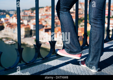 Mädchen lehnte sich gegen Brückengeländer an einem sonnigen Frühlingstag, Porto, Portugal Stockfoto