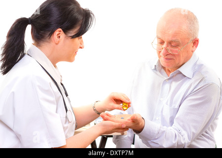 Doktor der Medizin zu einem älteren Mann zu geben. konzentrieren sich auf die Pillen Stockfoto