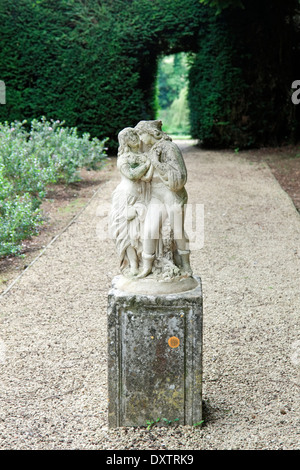 Eine romantische Statue eines umfassenden Paares in den Gärten der Wroxton Abbey, ein jakobinischen Haus, Wroxton, Oxfordshire, Vereinigtes Königreich. Stockfoto