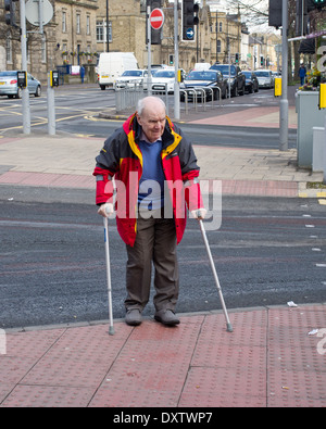 Senior woman überquert eine Stadtzentrum Straße in Keighley West Yorkshire UK Stockfoto