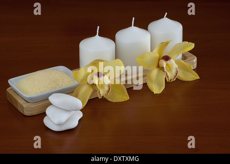 Spa-Einstellung mit Orchidee, Steinen, brennenden Kerzen und Salz Stockfoto