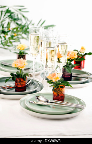 Tabelle-Präsentation mit Glas Crémant und Rosen Stockfoto