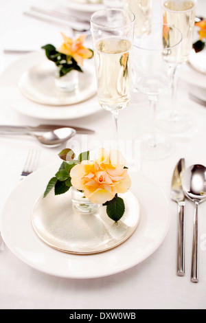 Tabelle-Präsentation mit Glas Crémant und Rosen Stockfoto