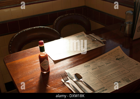 Diner Gewürze sitzen auf dem Tisch in einem Kleinstadt-Diner.  Tischsets werben lokale Unternehmen. Stockfoto