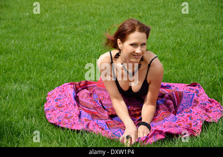 Junge Frau ruht auf dem Rasen-Grundstück Stockfoto